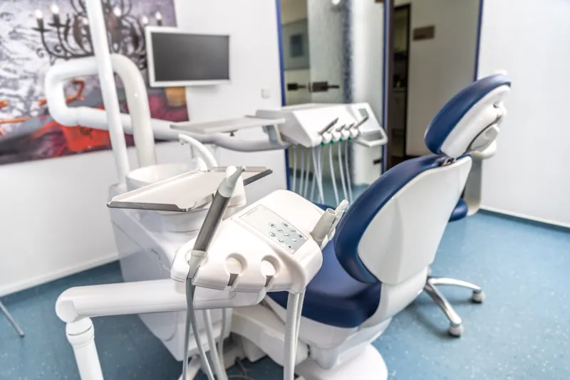 Behandlungszimmer mit blauem Behandlungsstuhl