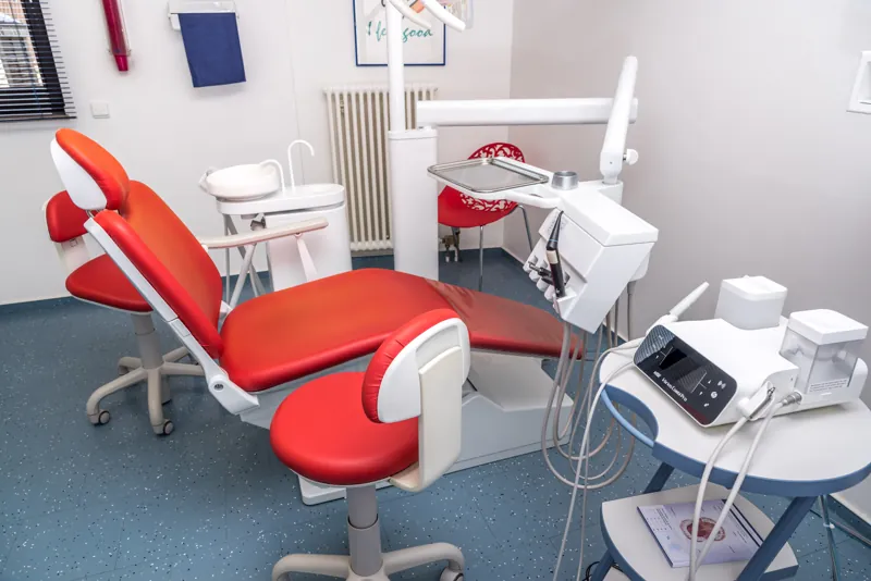 Behandlungszimmer mit rotem Behandlungsstuhl